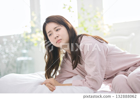 A young woman in pajamas sitting on the bed due to lack of sleep 132888062