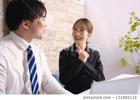 年輕男女在辦公室一邊看電腦一邊開會 132888118