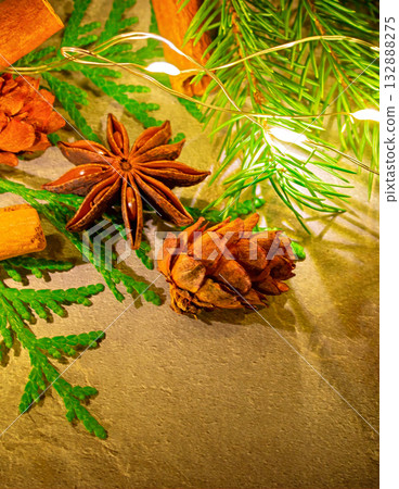 A Christmas photo featuring natural star anise and cinnamon sticks, along with fir branches and pine cones A Christmas photo featuring natural star anise and cinnamon sticks, along with fir branches and pine cones 132888275