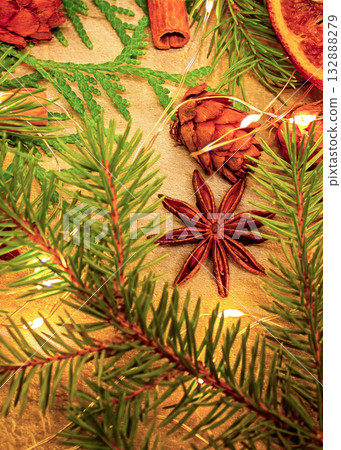 A Christmas photo featuring natural star anise and cinnamon sticks, along with fir branches and pine cones, and dried oranges A Christmas photo featuring natural star anise and cinnamon sticks, along with fir branches and pine cones, and dried oranges 132888279