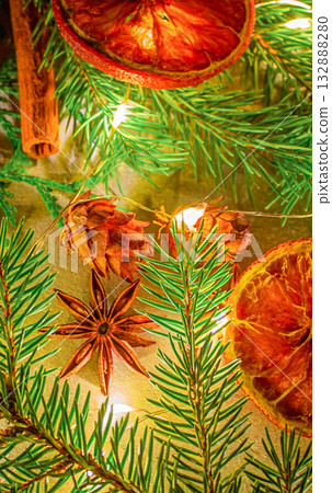 A Christmas photo featuring natural star anise and cinnamon stick, along with fir branches and pine cones, and dried oranges 132888280