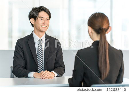一位年輕的亞洲商人正在與一位女顧客或女商人洽談、服務和會面。 一位年輕的亞洲商人正在與一位女顧客或女商人洽談、服務和會面。 132888440