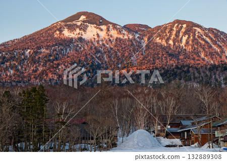 Mt. Hiuchigatake in the evening light seen from Ozegahara during the snowy season 132889308