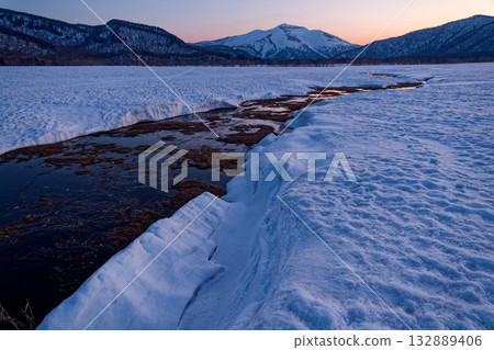 Mt. Shibutsu in the afterglow seen from the melting snow of Ozegahara 132889406