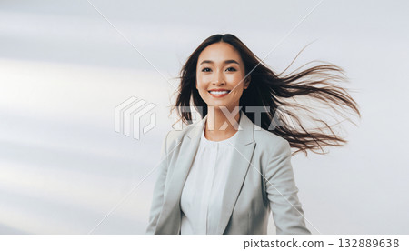 一位年輕的日本女商人面帶微笑,向前走去。 一位年輕的日本女商人面帶微笑,向前走去。 132889638