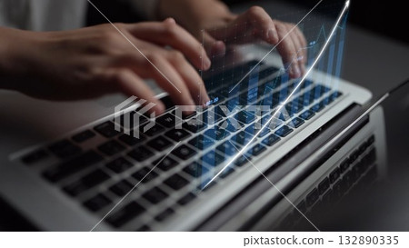 Hands of a professional typing on a laptop keyboard with digital graph overlay demonstrating data analysis and technology in a modern workspace Copula 132890335