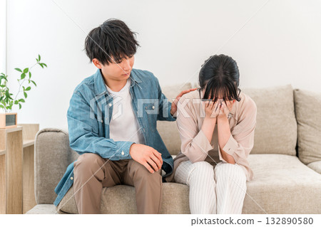 Man comforting depressed woman on sofa, married couple, couple (divorce, quarrel) 132890580