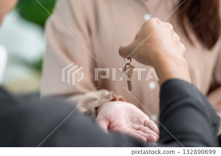 Real Estate Transaction. Handing over keys to a new homeowner in a professional setting. 132890699