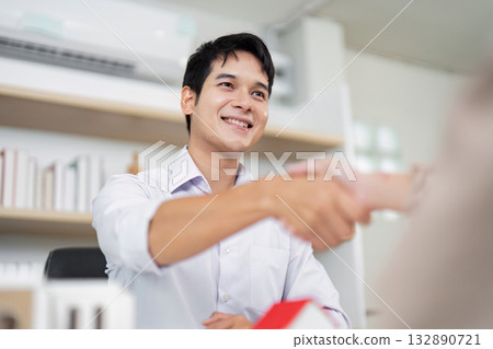 Real Estate Agreement. Agent and client shaking hands after a successful deal. Real Estate Agreement. Agent and client shaking hands after a successful deal. 132890721