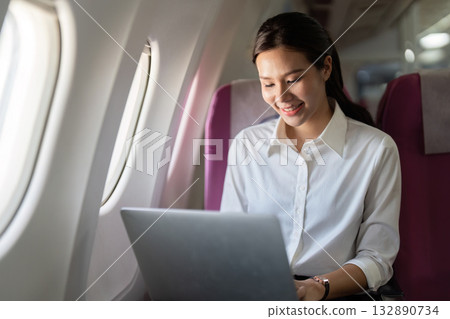 Productive Travel. Woman working on laptop in airplane. 132890734
