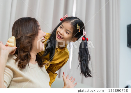 Joyful Moments. A mother and daughter sharing laughter at home. Joyful Moments. A mother and daughter sharing laughter at home. 132890738