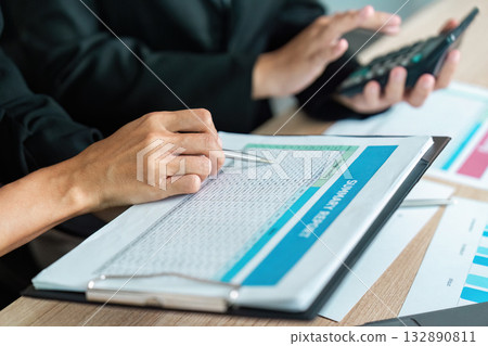 Collaborative Financial Review. Professional discussing financial report with colleague. 132890811