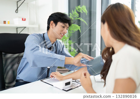 Patient Care Interaction. Doctor checking blood pressure during consultation. Patient Care Interaction. Doctor checking blood pressure during consultation. 132890816