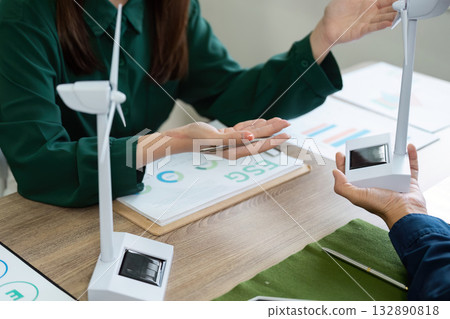 Sustainable Practices in ESG. Professionals discussing renewable energy solutions in an office. Sustainable Practices in ESG. Professionals discussing renewable energy solutions in an office. 132890818
