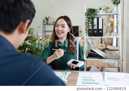 Sustainable Energy Collaboration. Professionals discussing renewable energy strategies with wind turbine model. 132890819