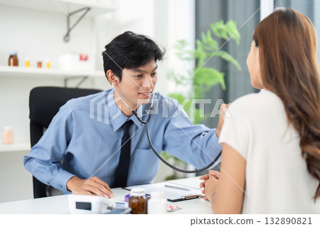 Healthcare Consultation. A doctor using a stethoscope to check a patient's health during a checkup. 132890821
