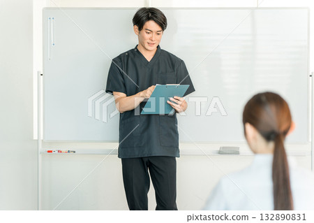 Male staff including doctors, nurses, and pharmacists explaining in front of a whiteboard at a medical conference 132890831