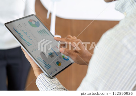 Data Visualization and Insights. Professional analyzing business metrics on tablet in modern office. Data Visualization and Insights. Professional analyzing business metrics on tablet in modern office. 132890926
