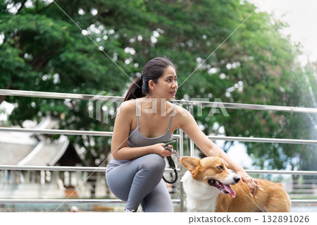 Wellness and Exercise. Young woman enjoying outdoor dog walk for fitness and mental health. Wellness and Exercise. Young woman enjoying outdoor dog walk for fitness and mental health. 132891026