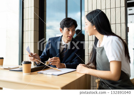 Strategic Business Meeting. Professionals discussing project details in a modern office space. 132891040