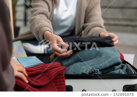 Travel Planning and Packing. Woman organizing clothing for a trip. 132891078