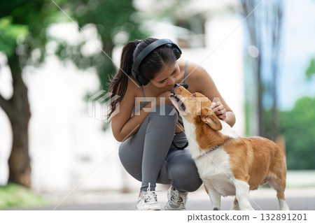 Pet Care and Wellness. Young woman enjoying quality time with her corgi outdoors. Pet Care and Wellness. Young woman enjoying quality time with her corgi outdoors. 132891201