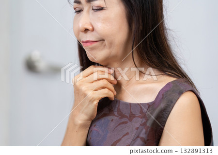 Senior woman experiencing throat discomfort and health concerns Senior woman experiencing throat discomfort and health concerns 132891313