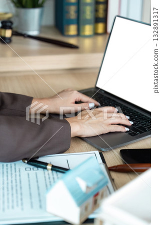 Legal Work. Lawyer typing on laptop with contract documents. 132891317