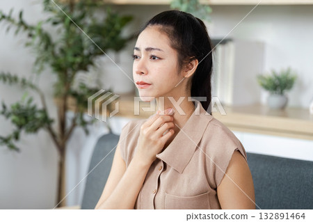 Health and Wellness. Woman touching throat, experiencing discomfort or health concern. 132891464