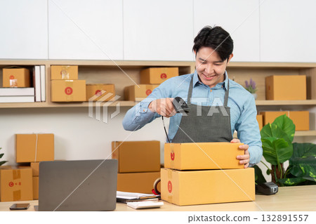 Entrepreneur scanning packages with barcode scanner in office 132891557