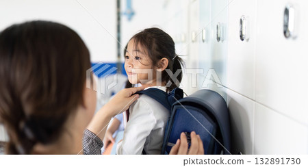 Back to School. Parent Helping Child with Backpack at School Locker 132891730