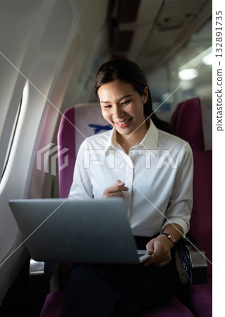 Business Travel. Professional woman working on laptop during flight. Business Travel. Professional woman working on laptop during flight. 132891735