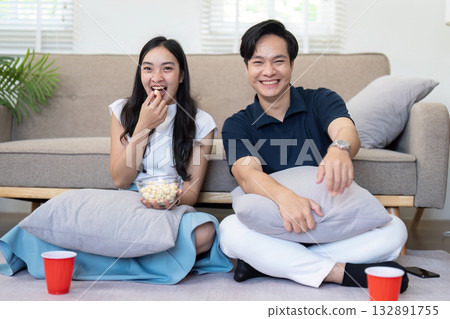 Couple enjoying movie night with popcorn at home Couple enjoying movie night with popcorn at home 132891755