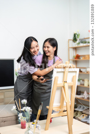 LGBTQ couple sharing a warm embrace while painting at home 132891889