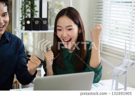 Excited Team Celebrating Success. Colleagues reacting joyfully to project results on laptop. 132891905