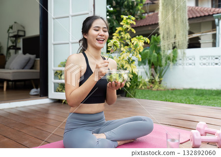 Healthy Eating and Fitness. Young woman enjoying a nutritious salad at home. 132892060