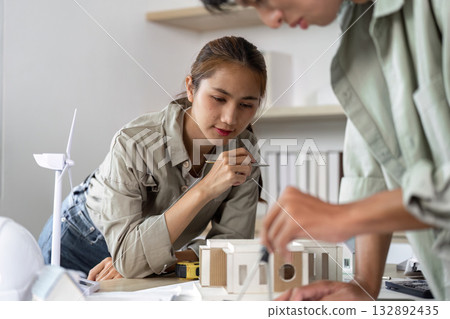 Architects Collaborating on Sustainable Design Project with Model 132892435