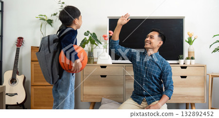 Father and Son Bonding. Joyful moment with a child waving goodbye before basketball practice. 132892452