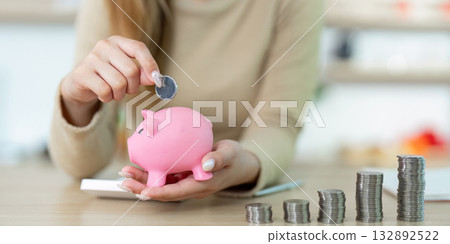 Financial Empowerment. Woman saving money in piggy bank with coins. 132892522