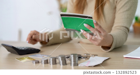 Budgeting and Financial Planning. Woman reviewing her finances with coins and cards. 132892523