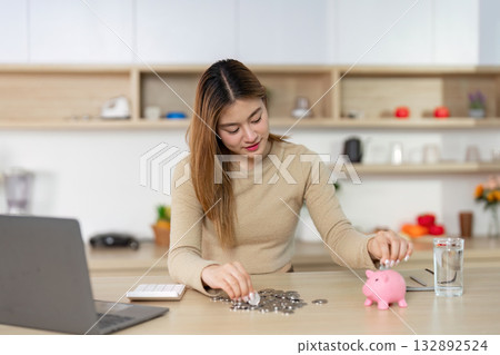 Financial Planning. Young Woman Depositing Coins into Piggy Bank Financial Planning. Young Woman Depositing Coins into Piggy Bank 132892524