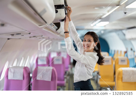 Business travel experience with young woman storing luggage on airplane Business travel experience with young woman storing luggage on airplane 132892585