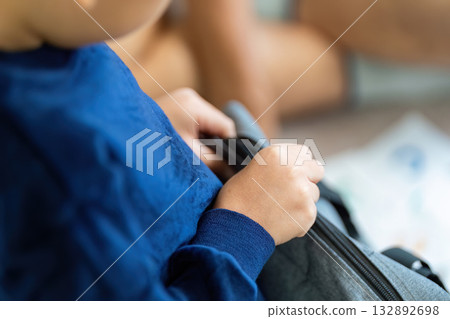 Back to School. Child opening a backpack to retrieve school supplies. Back to School. Child opening a backpack to retrieve school supplies. 132892698