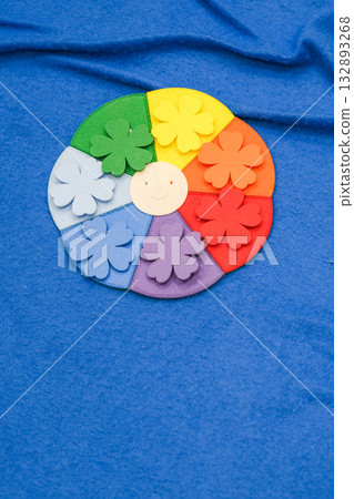 A colorful flower with a smiling face is on a blue background A colorful flower with a smiling face is on a blue background 132893268