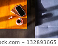 Coffee cup, smartphone and earphones on wooden table 132893665