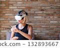 Boy wearing virtual reality headset and holding controller, exploring digital world. 132893667