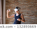 Teenager with blonde hair wearing vr headset and holding controller. 132893669