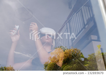 Teenager using virtual reality headset with controller. Teenager using virtual reality headset with controller. 132893670
