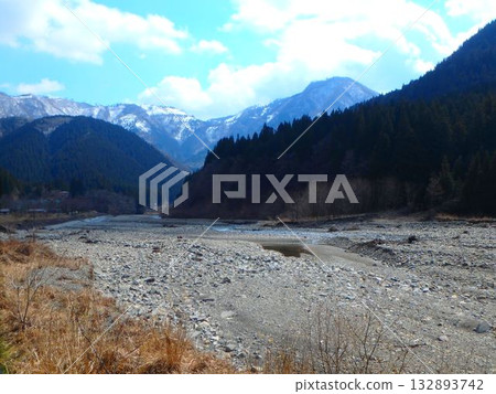 Between seasons, the contrast between the Neo River and the snowy mountains in early spring Between seasons, the contrast between the Neo River and the snowy mountains in early spring 132893742