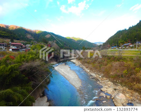 The clear waters of the Kamimura River, a tributary of the Yahagi River, enveloped in autumn colors 132893774